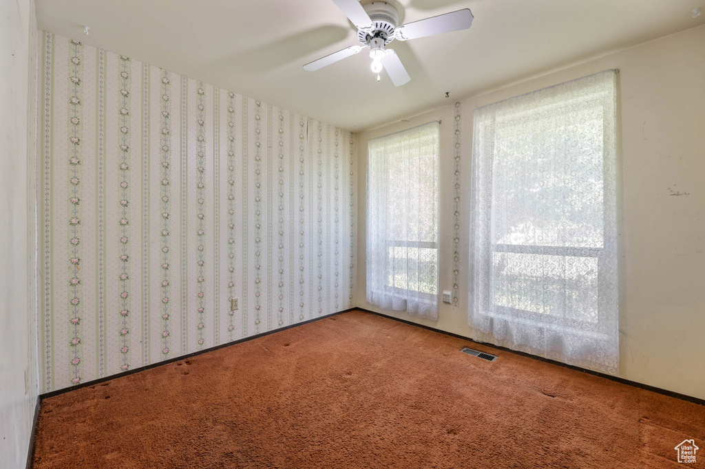 Carpeted spare room featuring ceiling fan