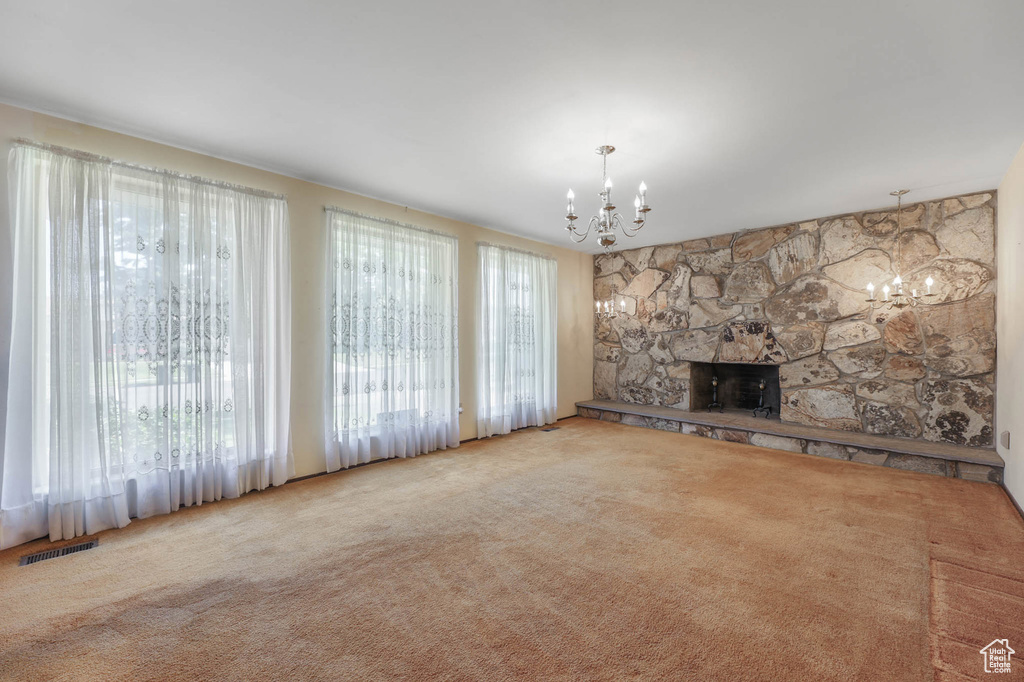Unfurnished living room with a chandelier and carpet floors
