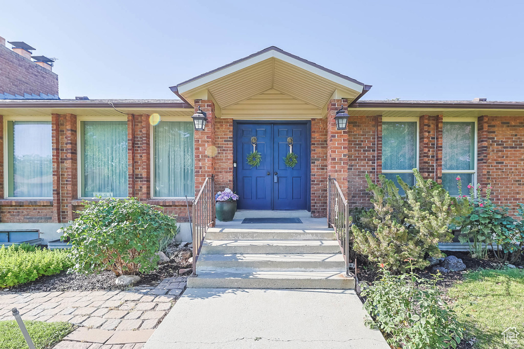 Entrance to property with brick siding and a chimney