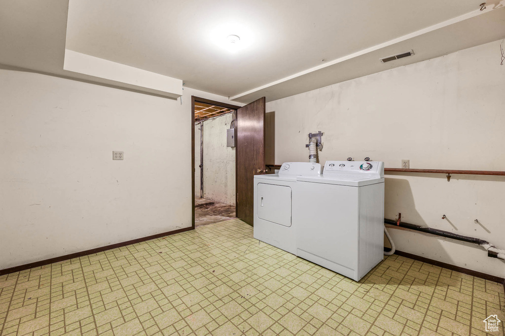 Washroom with washer and dryer and light flooring