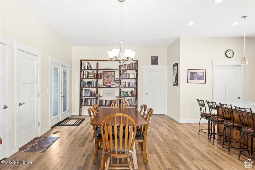 Dining area with light wood-type flooring, a chandelier, and recessed lighting