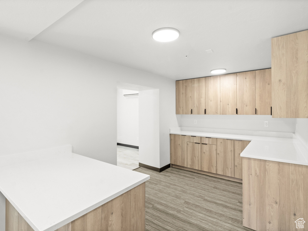 Kitchen with light brown cabinets, a peninsula, and light countertops