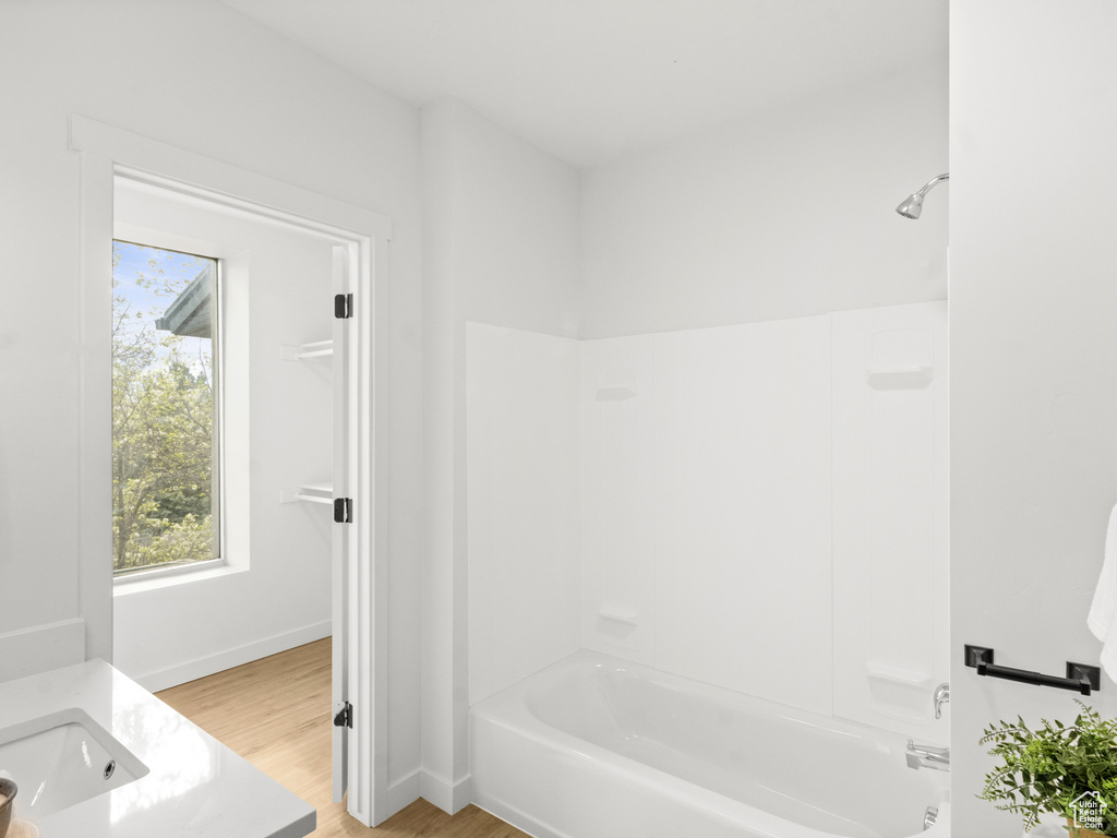 Full bath featuring bathing tub / shower combination, wood finished floors, and vanity