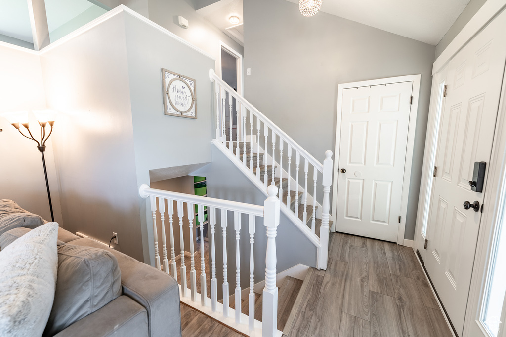 Foyer entrance featuring wood finished floors and vaulted ceiling