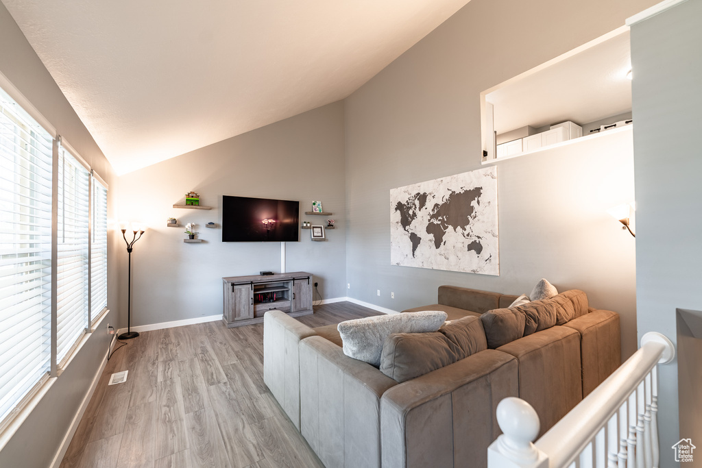 Living area with lofted ceiling and light wood-type flooring