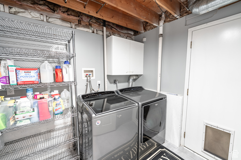Laundry area featuring washing machine and dryer and cabinet space