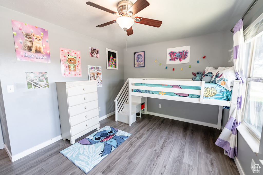 Bedroom featuring multiple windows, wood finished floors, and ceiling fan