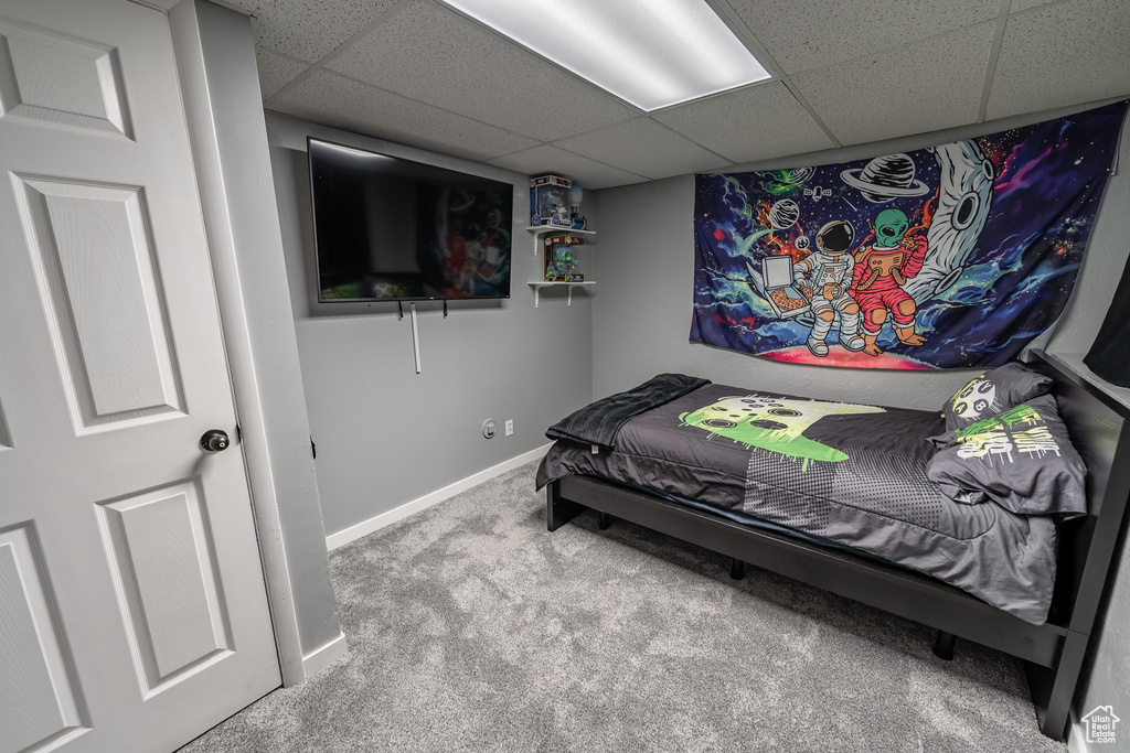 Bedroom with carpet floors and a drop ceiling