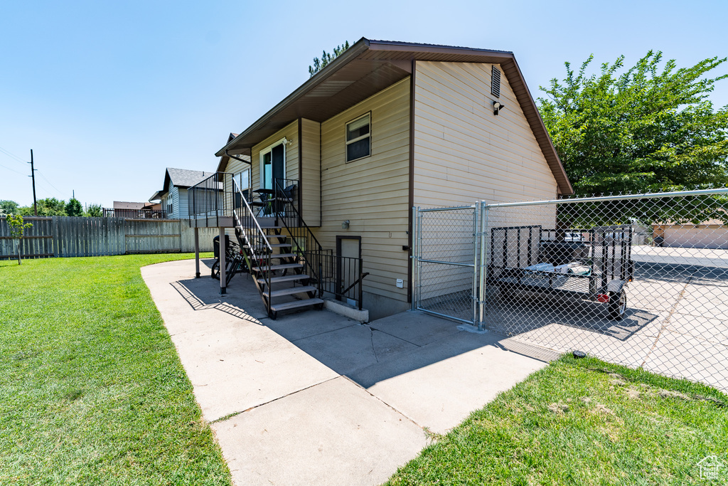View of outdoor structure featuring a gate, a fenced backyard, and stairs