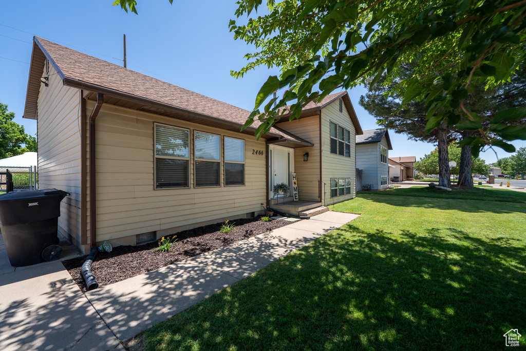 Tri-level home featuring a front yard and roof with shingles