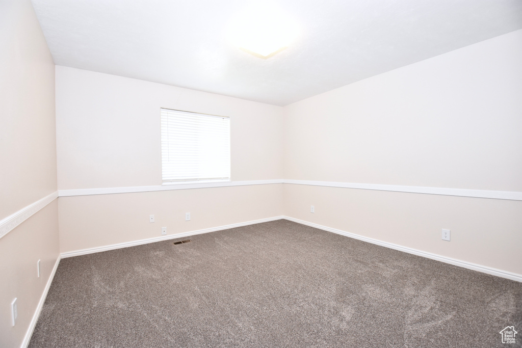 Carpeted empty room featuring baseboards