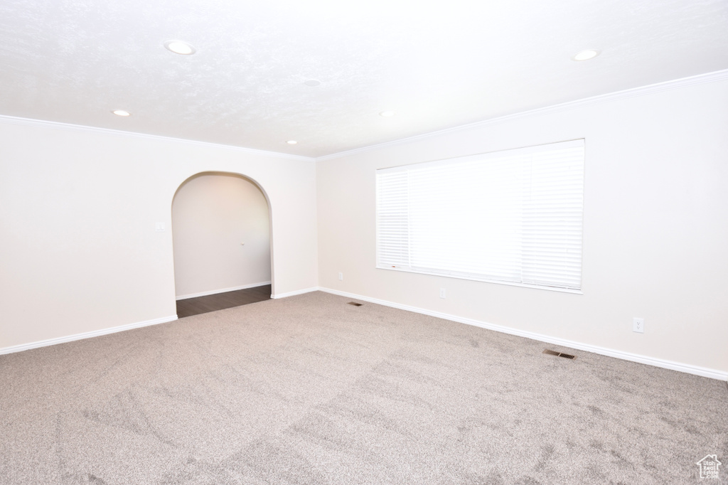 Unfurnished room with recessed lighting, carpet floors, crown molding, and arched walkways
