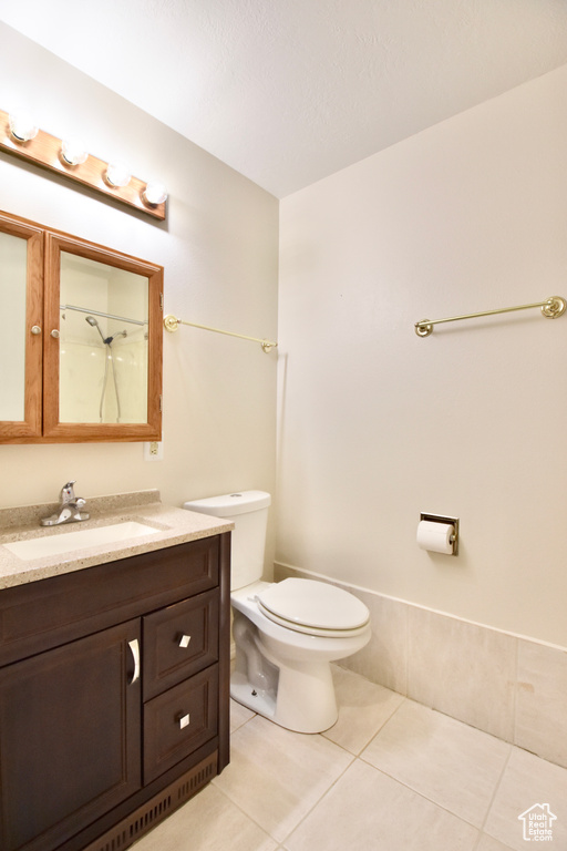 Full bathroom with tile patterned floors, vanity, and a shower