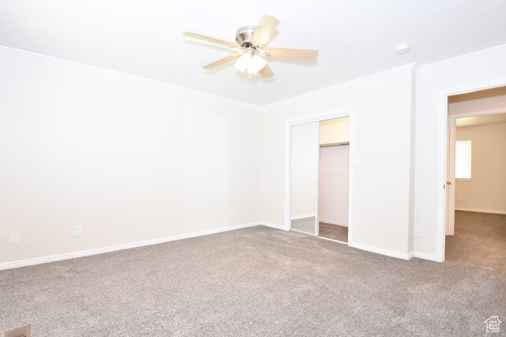 Unfurnished bedroom featuring crown molding, carpet floors, and ceiling fan