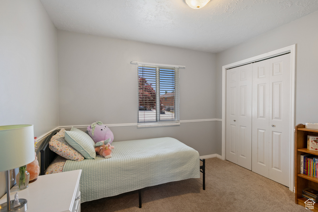 Carpeted bedroom with a closet