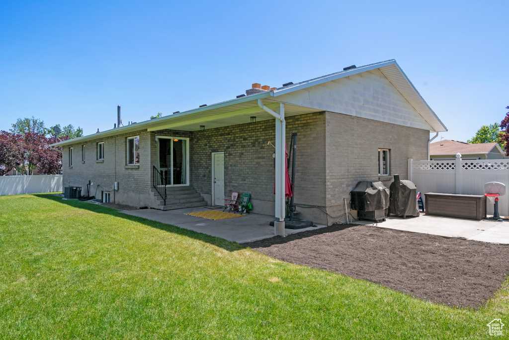 Rear view of house with brick siding, a patio area, and entry steps