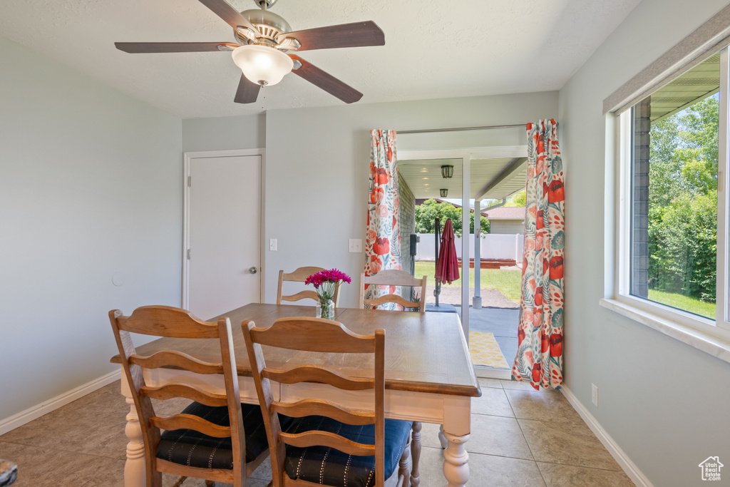 Dining room with plenty of natural light, light tile patterned floors, and ceiling fan