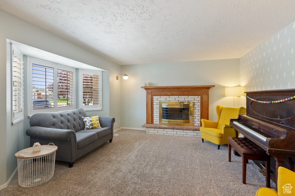 Carpeted living area featuring a textured ceiling and a fireplace