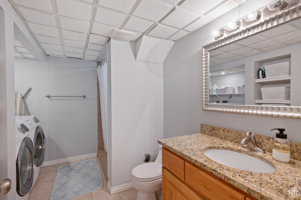 Full bath featuring separate washer and dryer, vanity, a shower with curtain, and tile patterned flooring