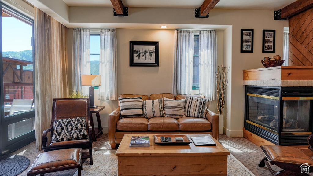 Living room featuring beam ceiling, a tiled fireplace, and a mountain view