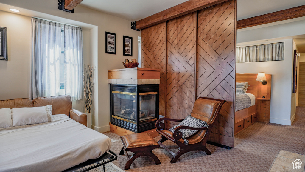 Carpeted bedroom with a tile fireplace, beam ceiling, and recessed lighting