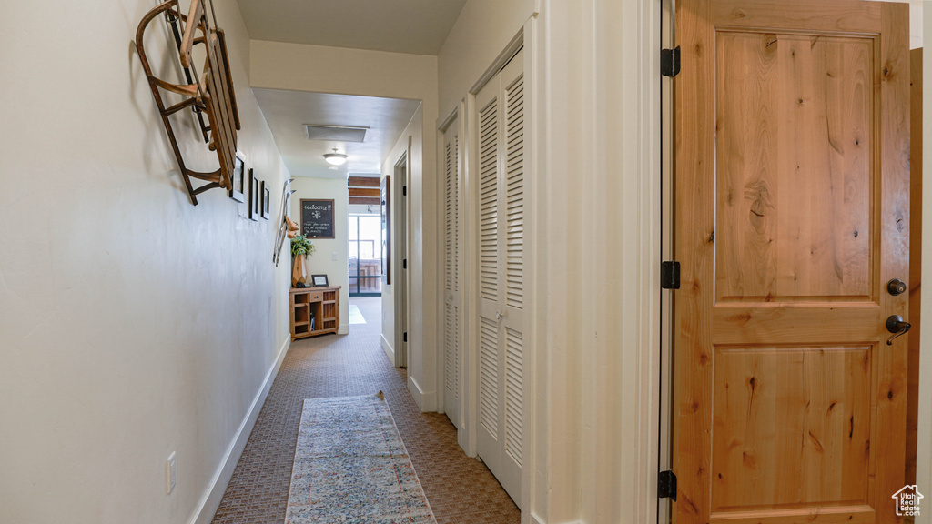 Hall featuring attic access and tile patterned floors