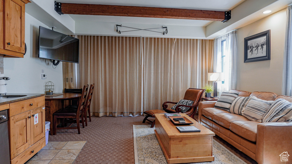 Living area featuring beam ceiling and light colored carpet