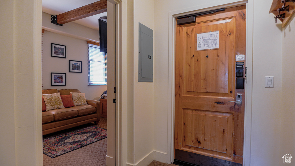 Foyer featuring beam ceiling and electric panel
