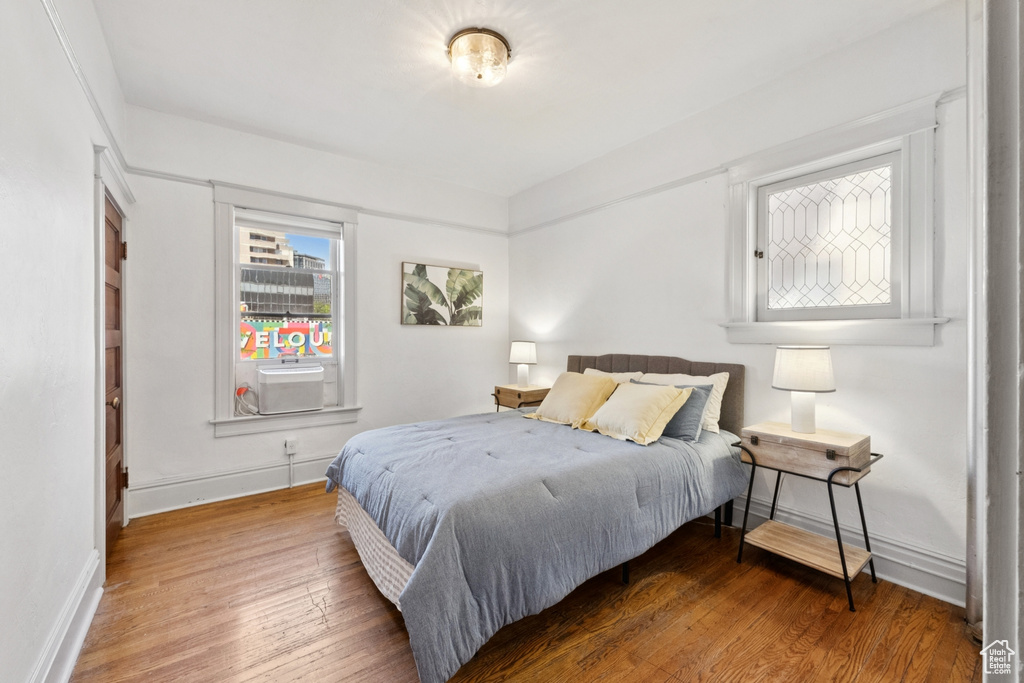 Bedroom with wood finished floors and cooling unit