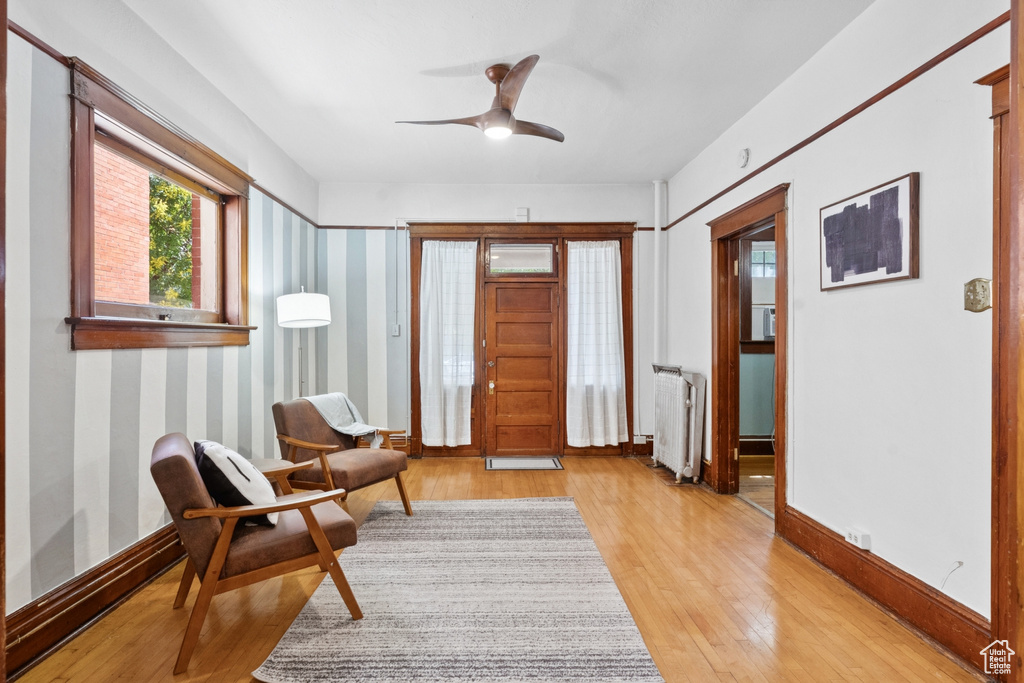Entrance foyer with radiator, light wood-type flooring, and ceiling fan