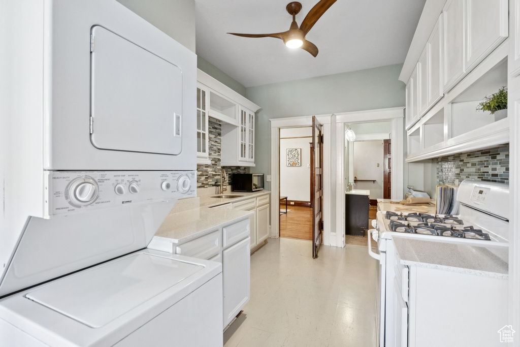 Washroom with estacked washer and dryer and ceiling fan