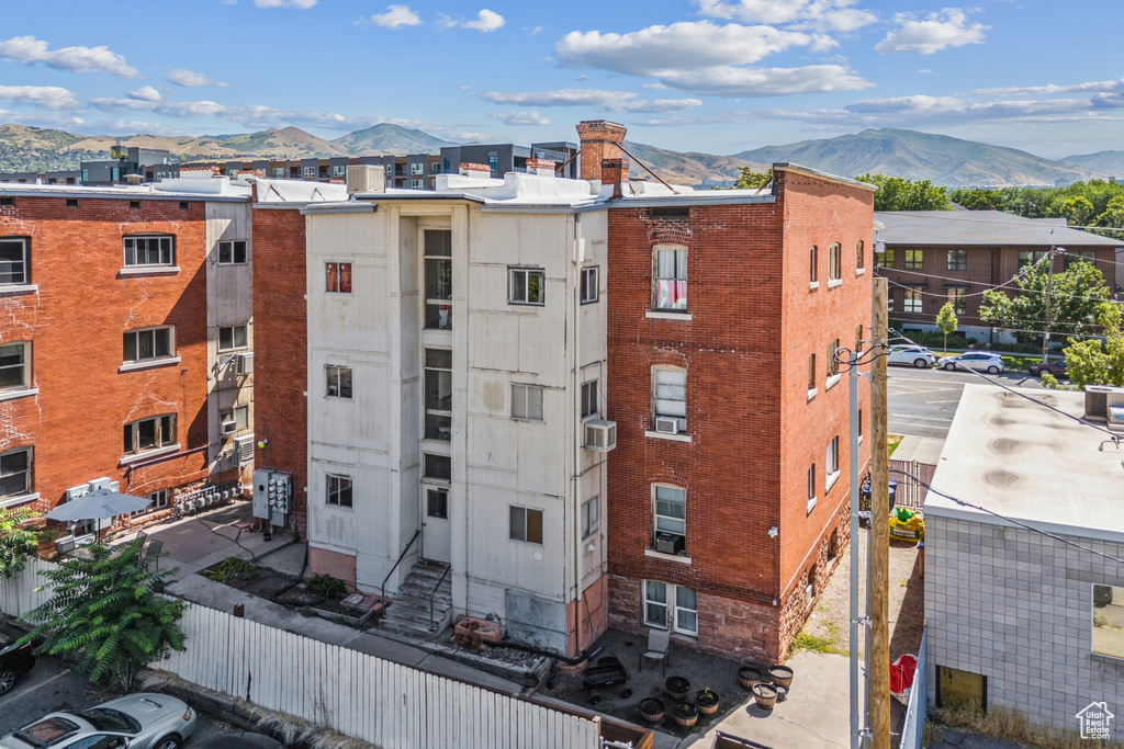 View of apartment building / complex featuring a mountain view and cooling unit