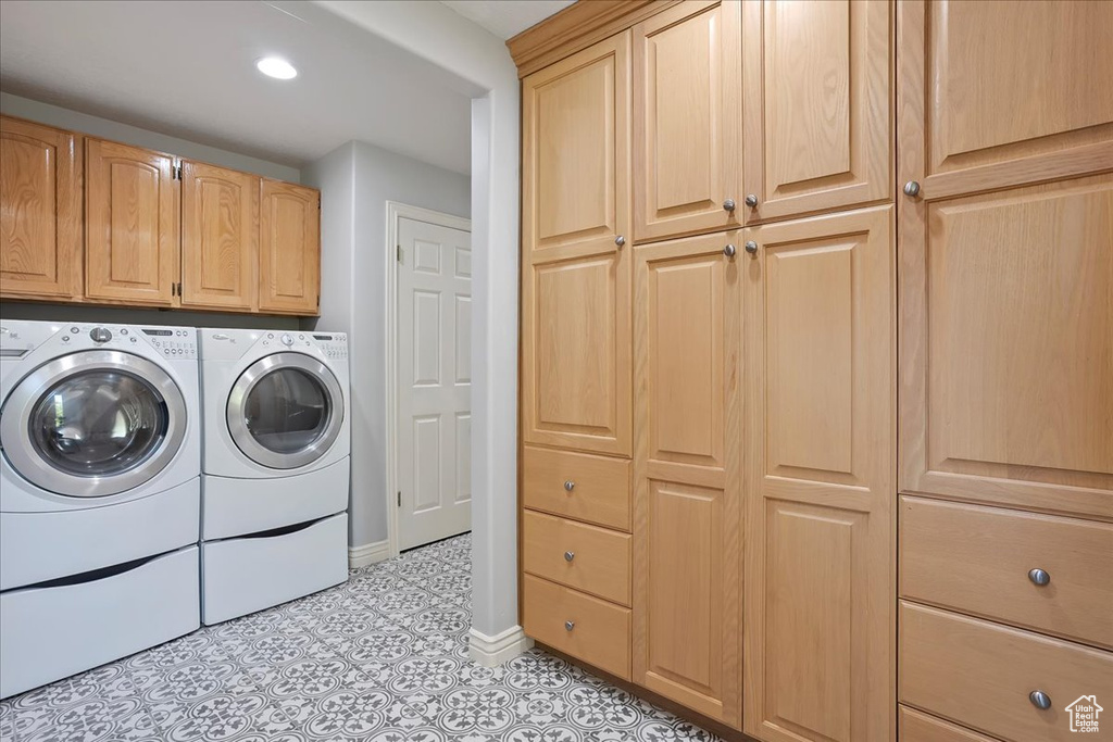 Washroom featuring washer and dryer, cabinet space, light tile patterned flooring, and recessed lighting