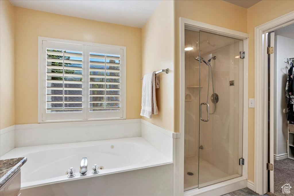 Full bath featuring a shower stall, a bath, and vanity
