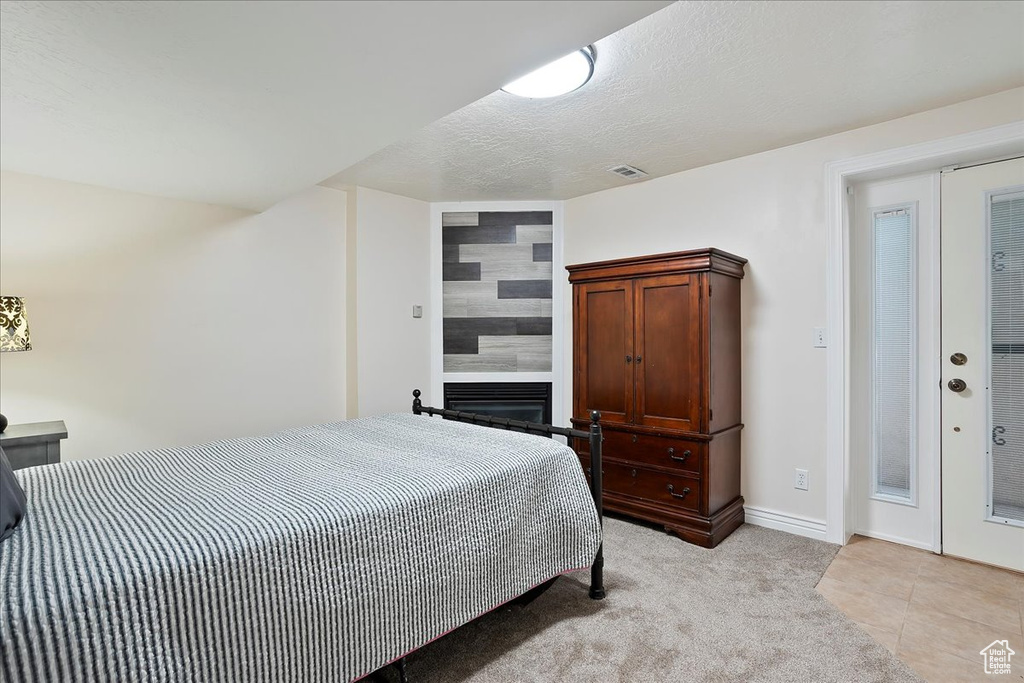 Bedroom featuring baseboards and a large fireplace