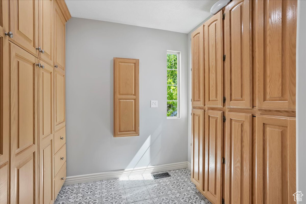 Hallway with baseboards and light tile patterned flooring