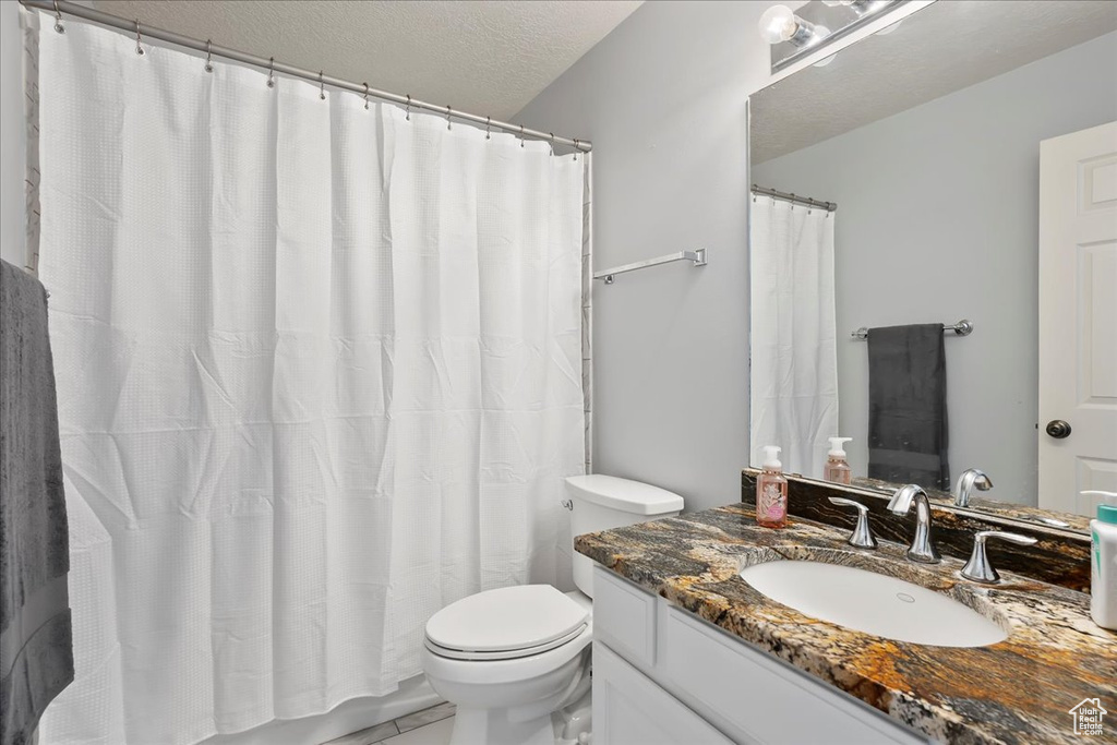 Full bath featuring vanity, a textured ceiling, and a shower with curtain