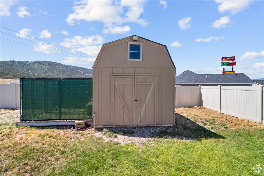 View of shed with a fenced backyard and a mountain view