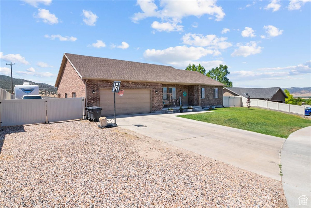 Ranch-style house with a gate, brick siding, driveway, a garage, and a shingled roof