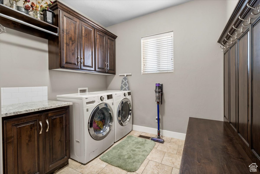 Washroom with cabinet space and washing machine and clothes dryer
