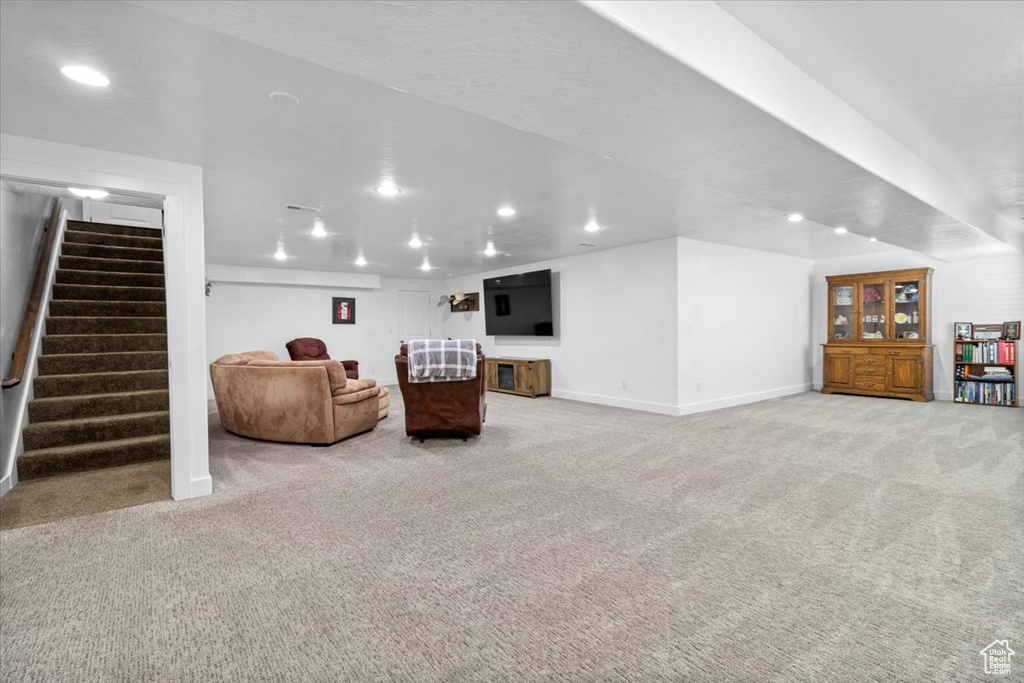Living room with recessed lighting, light carpet, and stairs