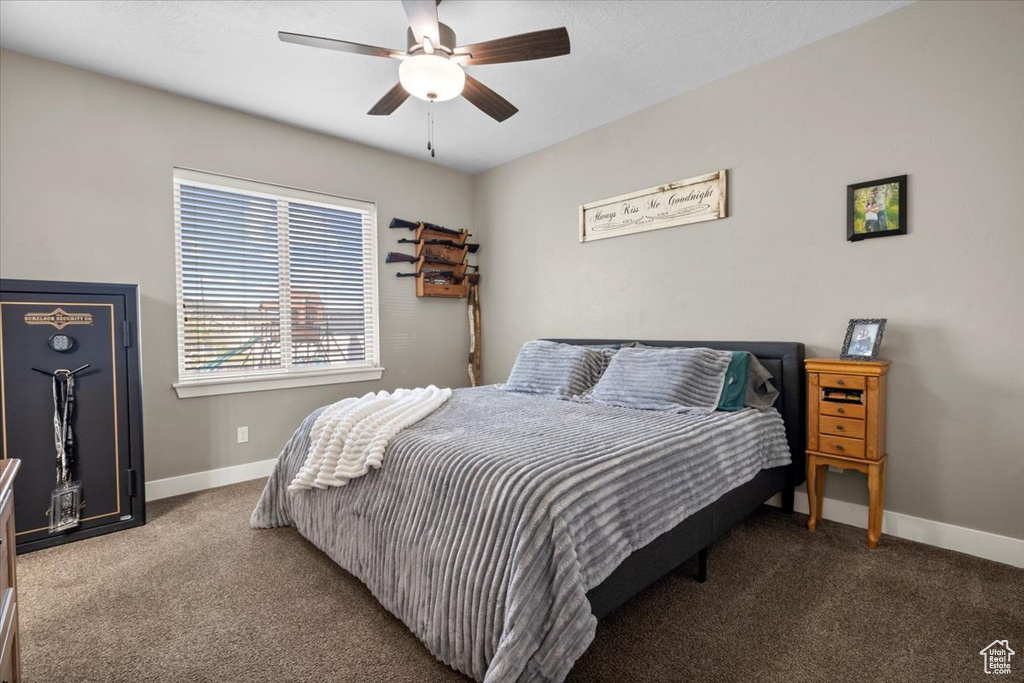 Carpeted bedroom featuring baseboards and ceiling fan