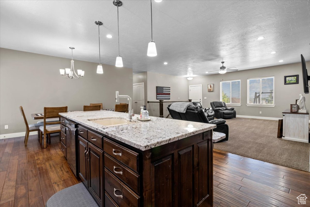 Kitchen with a chandelier, ceiling fan, dark brown cabinets, dark wood-type flooring, and hanging light fixtures