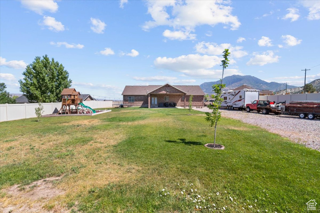 Fenced yard with a playground and a mountain view