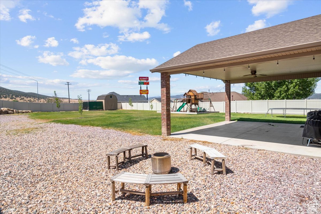 View of home's community with a playground, a patio, and an outdoor structure