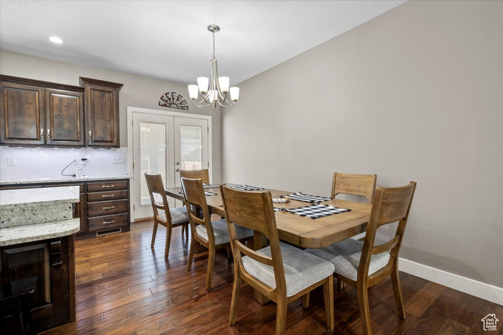 Dining area featuring a chandelier, dark wood-type flooring, french doors, and recessed lighting