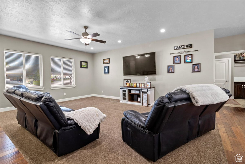 Living area featuring a ceiling fan, recessed lighting, hardwood / wood-style flooring, and a textured ceiling