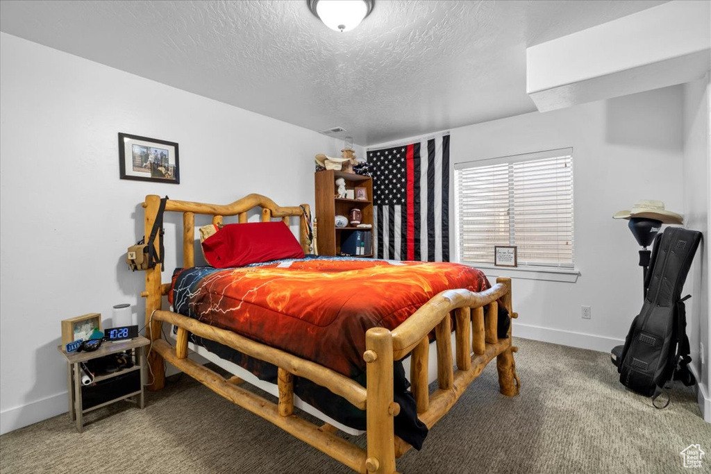 Bedroom featuring a textured ceiling and carpet flooring