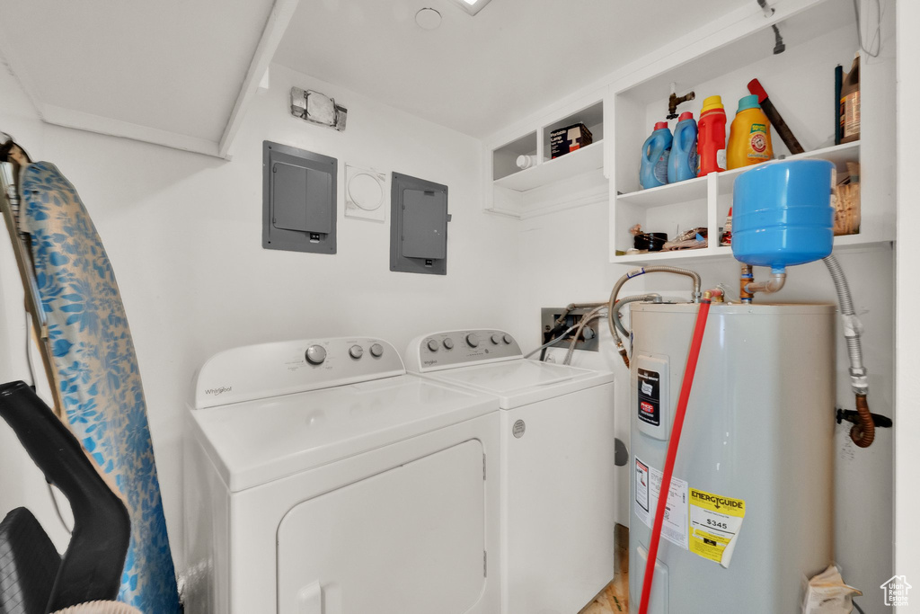 Laundry area with water heater, electric panel, and washing machine and clothes dryer