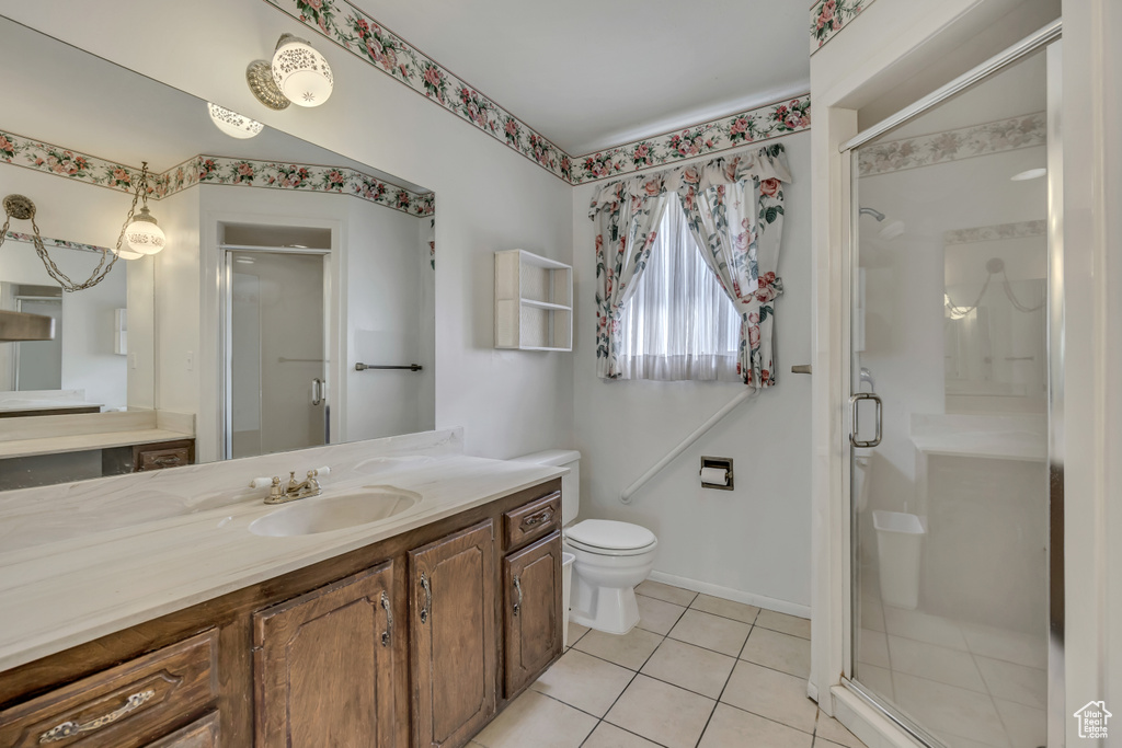 Full bath with vanity, a stall shower, and tile patterned floors